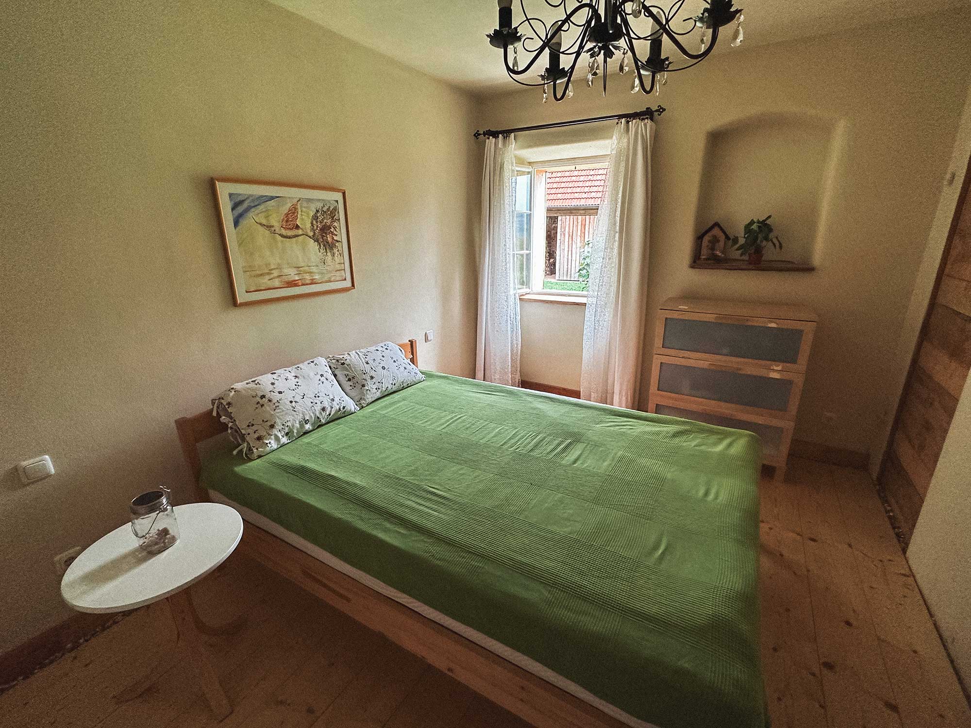 Schlafzimmer mit Doppelbett und Luster
